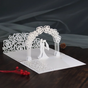Detailed 3D laser-cut white wedding invitation with rose arch and couple silhouette