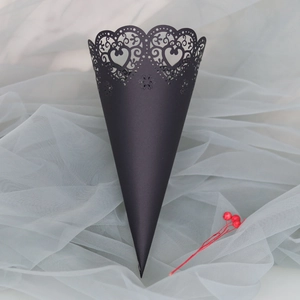 Detail of black laser-cut wedding petal cones with intricate heart lace patterns