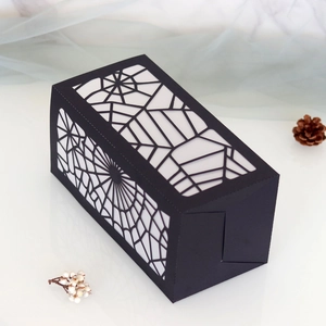Detailed laser-cut spider web patterns on a black Halloween decorative gift box