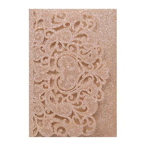 Detail of rose gold glitter wedding invitation with intricate laser-cut floral patterns