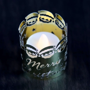 Macro view of gold metal Christmas candle holder with Merry Christmas cutout design