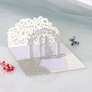 Detailed laser-cut silver glitter wedding card showing 3D bride and groom under an arch
