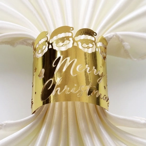 Détail d'un rond de serviette doré Merry Christmas avec motif de Père Noël