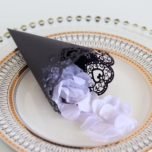 Close-up of laser-cut black paper cone with heart pattern and purple petals
