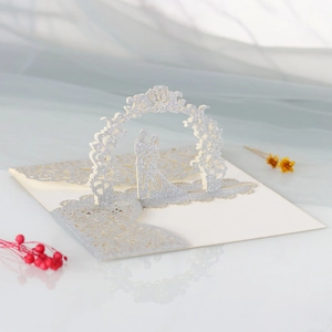 Détail macro d'un faire-part de mariage 3D en argent pailleté avec un couple romantique