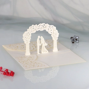 Macro view of 3D laser cut wedding card with cream white rose arch and bride groom silhouette