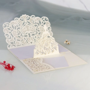 Close-up of laser-cut 3D bride silhouette on elegant cream-white invitation card