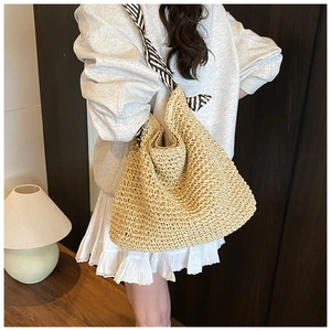Détail d'un sac cabas en paille tissé main avec une large bandoulière à rayures zébrées