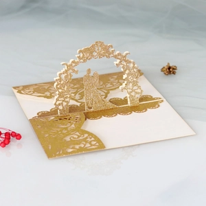 Detailed 3D laser-cut wedding invitation featuring golden glitter and romantic couple silhouette