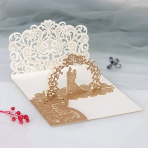 Detail of 3D laser cut wedding invitation featuring golden glitter and lace pattern