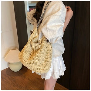 Détail du grand sac cabas en paille avec bandoulière à rayures noires et blanches et texture