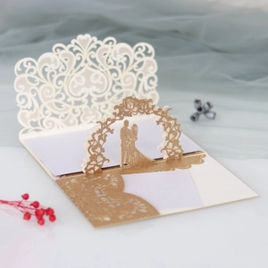 Detail of laser-cut lace wedding invitation with pop-up bride and groom silhouette