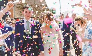 Dynamic view of colorful wedding confetti floating around a couple in a celebration