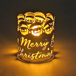 Close-up of metal hollow candle holder with Merry Christmas and Santa Claus design