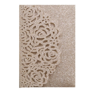 Macro view of laser-cut rose patterns on champagne gold glitter wedding invitation