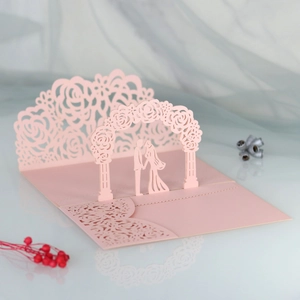 Detailed 3D laser cut wedding card showing a couple under a rose arch in light pink