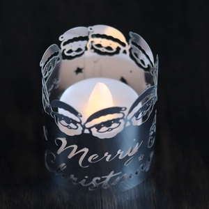 Close-up of LED Christmas candle with Merry Christmas metal cover and Santa cutout