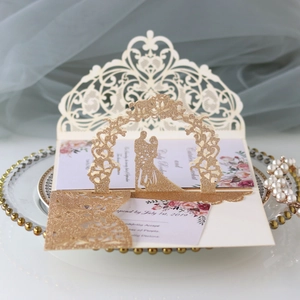 Detail of 3D pop-up wedding invitation featuring laser-cut rose patterns and champagne gold glitter