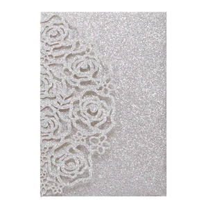 Detail view of silver glitter wedding invitation with laser-cut rose flower design
