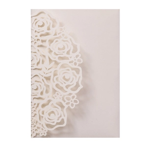 Detail of laser-cut cream lace rose pattern on luxury cardstock for wedding invitations
