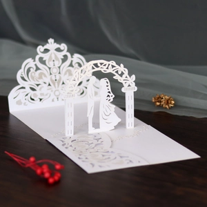 Close-up of laser-cut 3D wedding invitation with delicate lace and bride silhouette