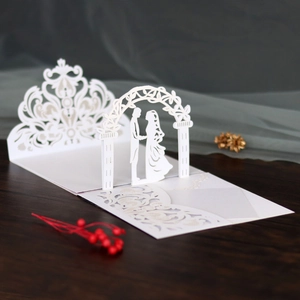 Macro shot of 3D laser-cut lace wedding card featuring a romantic couple silhouette