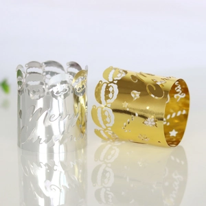 Macro shot of gold and silver Merry Christmas cutout napkin rings with reindeer patterns