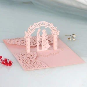 Dettaglio di un invito 3D tagliato al laser con ghirlanda rosa e silhouette di coppia
