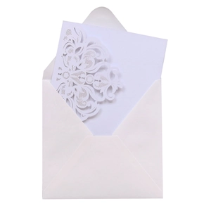 Close-up of laser cut floral invitation card and white envelope for weddings