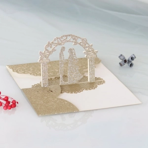 Detail of laser-cut glitter wedding card with 3D floral arch and couple silhouette