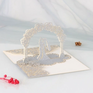 Detail of 3D pop-up wedding card featuring laser-cut rose arch and silver glitter lovers