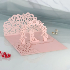Dettaglio dell'invito di nozze 3D tagliato al laser con motivi di rose e una coppia