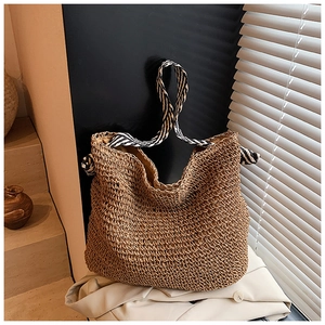 Détail du sac fourre-tout en paille tressée avec anses en tissu rayé noir et blanc