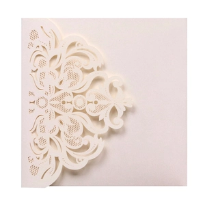 Close-up of cream white laser cut lace wedding invitation with floral hollow design