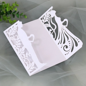 Detail of white laser cut wedding invitation featuring romantic couple silhouette design