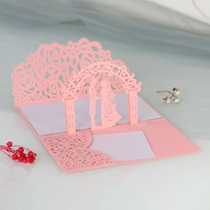 Motivi di rose tagliati al laser e sposi pop-up 3D su un invito di matrimonio rosa