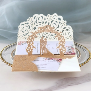 Détail d'invitation de mariage découpée au laser avec motif de rose ajouré en or champagne