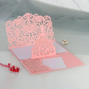 Detail of pink laser-cut invitation card with 3D girl figure and heart pattern