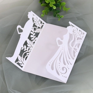 Detail of laser-cut wedding invitation featuring bride and groom silhouette in white card