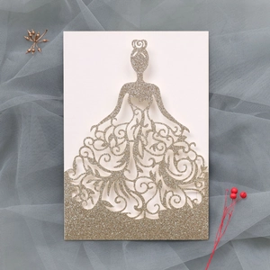Détail de l'invitation découpée au laser avec finition pailletée dorée et motif robe