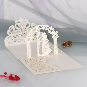 Detail of 3D laser-cut wedding invitation featuring a romantic couple under floral arch