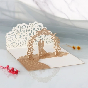 Détail d'une carte de mariage 3D avec silhouette de couple pailletée dorée et roses
