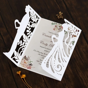 Detailed laser-cut wedding invitation featuring bride and groom silhouette on wood