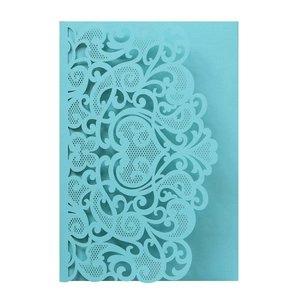 Detailed laser-cut floral and heart hollow patterns on a light blue wedding invitation