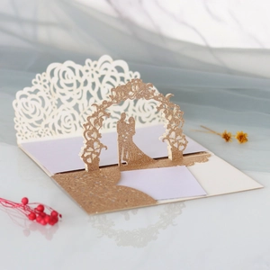 Invitation de mariage découpée au laser avec motifs roses et accents dorés brillants