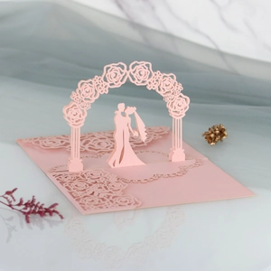 3D pop-up wedding invitation featuring laser-cut bride and groom under a rose arch