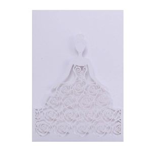Macro shot of white laser-cut wedding invitation featuring rose pattern and bridal silhouette