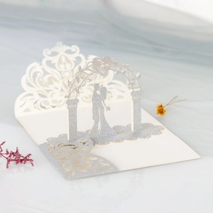 Macro view of laser-cut 3D wedding card with silver glitter silhouette and floral pattern
