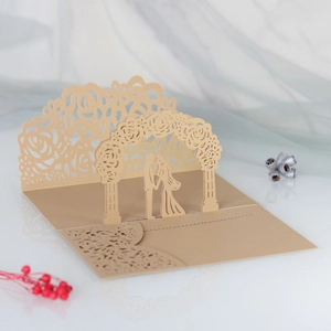 3D laser cut wedding invitation card featuring a champagne gold pop-up couple under roses