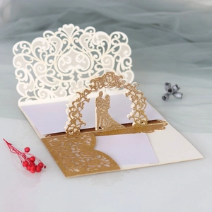 Detailed macro view of laser-cut 3D pop-up wedding invitation with gold glitter textures